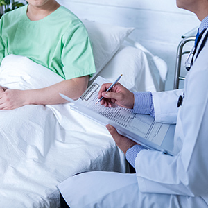 photograph of patient in hospital bed talking to a doctor