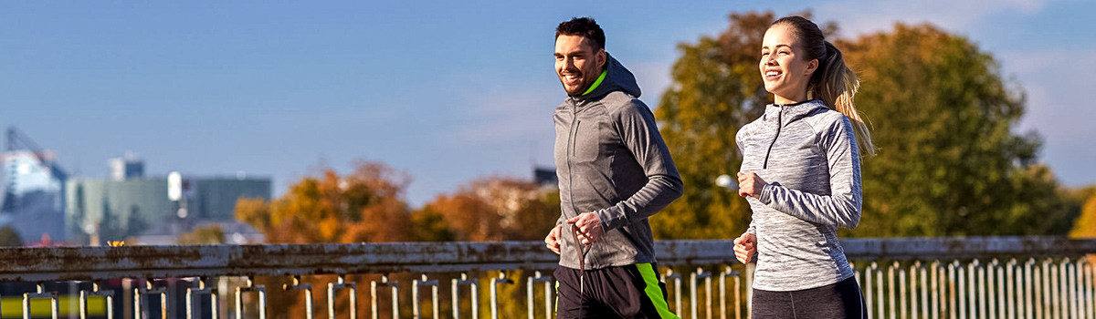 A happy couple running outdoors