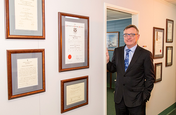 Photograph of Associate Professor Kon Kozak, Orthopaedic Surgeon with certificates